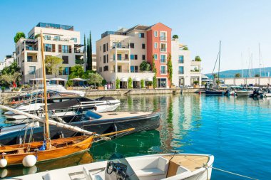 Tivat, Karadağ - 28 Haziran 2021: Porto Karadağ 'daki yat marinasının deniz kenarındaki konutları ve güzel gezinti alanlarıyla gün batımı manzarası