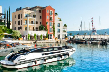 Tivat, Karadağ - 28 Haziran 2021: Porto Karadağ 'daki yat marinasının deniz kenarındaki konutları ve güzel gezinti alanlarıyla gün batımı manzarası