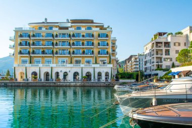 Tivat, Karadağ - 28 Haziran 2021: Porto Karadağ 'daki yat marinasının deniz kenarındaki konutları ve güzel gezinti alanlarıyla gün batımı manzarası