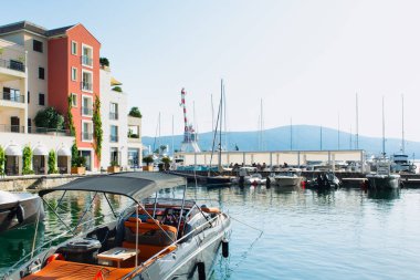 Tivat, Karadağ - 28 Haziran 2021: Porto Karadağ 'daki yat marinasının deniz kenarındaki konutları ve güzel gezinti alanlarıyla gün batımı manzarası
