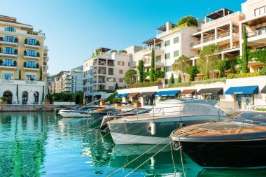 Tivat, Karadağ - 28 Haziran 2021: Porto Karadağ 'daki yat marinasının deniz kenarındaki konutları ve güzel gezinti alanlarıyla gün batımı manzarası