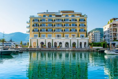 Tivat, Karadağ - 28 Haziran 2021: Porto Karadağ 'daki yat marinasının deniz kenarındaki konutları ve güzel gezinti alanlarıyla gün batımı manzarası