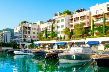 Tivat, Karadağ - 28 Haziran 2021: Porto Karadağ 'daki yat marinasının deniz kenarındaki konutları ve güzel gezinti alanlarıyla gün batımı manzarası