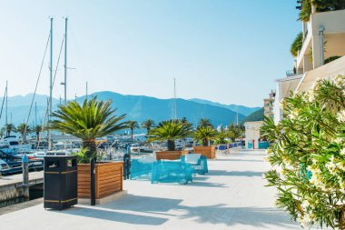 Tivat, Karadağ - 28 Haziran 2021: Porto Karadağ 'daki yat marinasının deniz kenarındaki konutları ve güzel gezinti alanlarıyla gün batımı manzarası