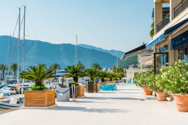 Tivat, Karadağ - 28 Haziran 2021: Porto Karadağ 'daki yat marinasının deniz kenarındaki konutları ve güzel gezinti alanlarıyla gün batımı manzarası