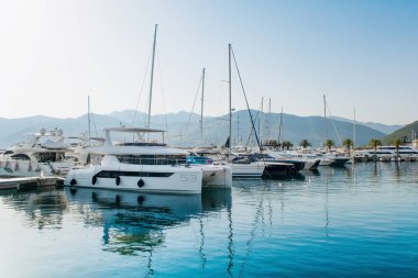Tivat, Karadağ - 28 Haziran 2021: Porto Karadağ 'daki yat marinasının deniz kenarındaki konutları ve güzel gezinti alanlarıyla gün batımı manzarası