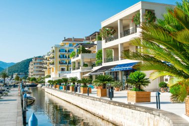 Tivat, Karadağ - 28 Haziran 2021: Porto Karadağ 'daki yat marinasının deniz kenarındaki konutları ve güzel gezinti alanlarıyla gün batımı manzarası