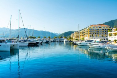 Tivat, Karadağ - 28 Haziran 2021: Porto Karadağ 'daki yat marinasının deniz kenarındaki konutları ve güzel gezinti alanlarıyla gün batımı manzarası
