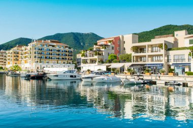 Tivat, Karadağ - 28 Haziran 2021: Porto Karadağ 'daki yat marinasının deniz kenarındaki konutları ve güzel gezinti alanlarıyla gün batımı manzarası