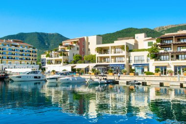 Tivat, Karadağ - 28 Haziran 2021: Porto Karadağ 'daki yat marinasının deniz kenarındaki konutları ve güzel gezinti alanlarıyla gün batımı manzarası