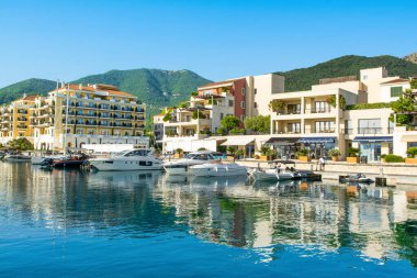 Tivat, Karadağ - 28 Haziran 2021: Porto Karadağ 'daki yat marinasının deniz kenarındaki konutları ve güzel gezinti alanlarıyla gün batımı manzarası