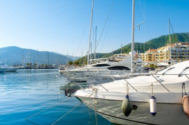 Tivat, Karadağ - 28 Haziran 2021: Porto Karadağ 'daki yat marinasının deniz kenarındaki konutları ve güzel gezinti alanlarıyla gün batımı manzarası
