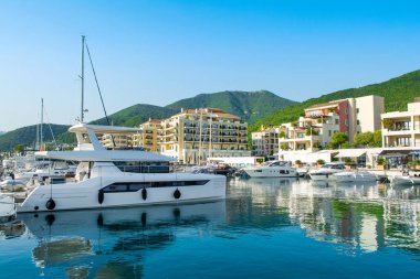 Tivat, Karadağ - 28 Haziran 2021: Porto Karadağ 'daki yat marinasının deniz kenarındaki konutları ve güzel gezinti alanlarıyla gün batımı manzarası
