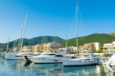 Tivat, Karadağ - 28 Haziran 2021: Porto Karadağ 'daki yat marinasının deniz kenarındaki konutları ve güzel gezinti alanlarıyla gün batımı manzarası