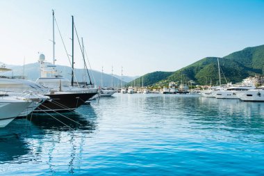 Tivat, Karadağ - 28 Haziran 2021: Porto Karadağ 'daki yat marinasının deniz kenarındaki konutları ve güzel gezinti alanlarıyla gün batımı manzarası