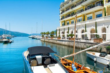 Tivat, Karadağ - 28 Haziran 2021: Porto Karadağ 'daki yat marinasının deniz kenarındaki konutları ve güzel gezinti alanlarıyla gün batımı manzarası