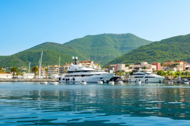 Tivat, Karadağ - 28 Haziran 2021: Porto Karadağ 'daki yat marinasının deniz kenarındaki konutları ve güzel gezinti alanlarıyla gün batımı manzarası
