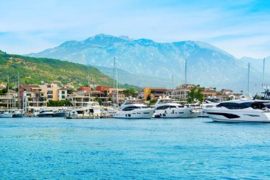 Porto Karadağ 'daki yat marinasının deniz kenarındaki konutları ve güzel gezinti alanlarıyla gün batımı manzarası