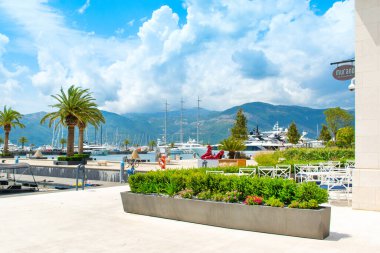 Tivat, Karadağ - 28 Haziran 2021: Porto Karadağ 'daki yat marinasının deniz kenarındaki konutları ve güzel gezinti alanlarıyla gün batımı manzarası