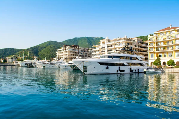 Tivat, Karadağ - 28 Haziran 2021: Porto Karadağ 'daki yat marinasının deniz kenarındaki konutları ve güzel gezinti alanlarıyla gün batımı manzarası