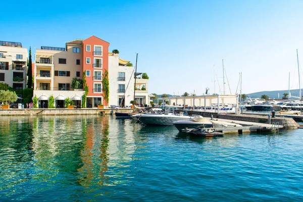 Tivat, Karadağ - 28 Haziran 2021: Porto Karadağ 'daki yat marinasının deniz kenarındaki konutları ve güzel gezinti alanlarıyla gün batımı manzarası