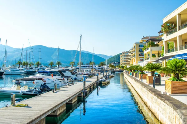 Tivat, Karadağ - 28 Haziran 2021: Porto Karadağ 'daki yat marinasının deniz kenarındaki konutları ve güzel gezinti alanlarıyla gün batımı manzarası