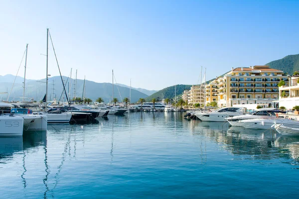 Tivat, Karadağ - 28 Haziran 2021: Porto Karadağ 'daki yat marinasının deniz kenarındaki konutları ve güzel gezinti alanlarıyla gün batımı manzarası