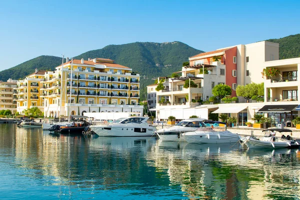 Tivat, Karadağ - 28 Haziran 2021: Porto Karadağ 'daki yat marinasının deniz kenarındaki konutları ve güzel gezinti alanlarıyla gün batımı manzarası
