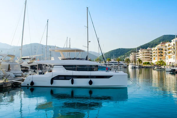Tivat, Karadağ - 28 Haziran 2021: Porto Karadağ 'daki yat marinasının deniz kenarındaki konutları ve güzel gezinti alanlarıyla gün batımı manzarası