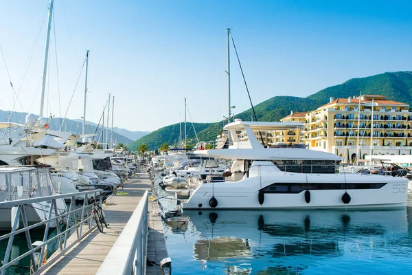 Tivat, Karadağ - 28 Haziran 2021: Porto Karadağ 'daki yat marinasının deniz kenarındaki konutları ve güzel gezinti alanlarıyla gün batımı manzarası
