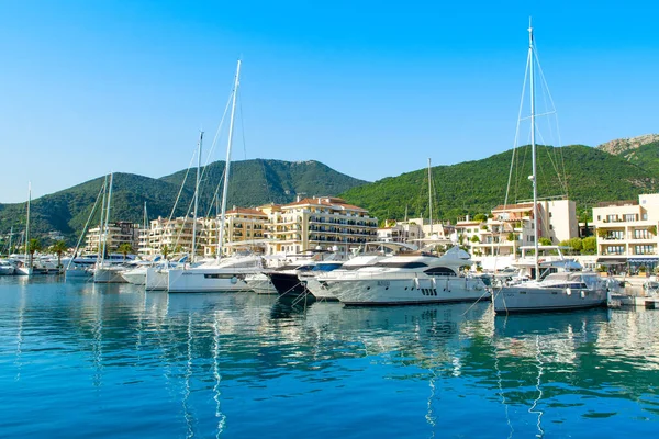 Tivat, Karadağ - 28 Haziran 2021: Porto Karadağ 'daki yat marinasının deniz kenarındaki konutları ve güzel gezinti alanlarıyla gün batımı manzarası