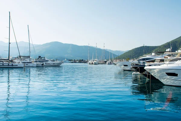 Tivat, Karadağ - 28 Haziran 2021: Porto Karadağ 'daki yat marinasının deniz kenarındaki konutları ve güzel gezinti alanlarıyla gün batımı manzarası