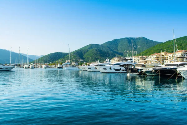 Tivat, Karadağ - 28 Haziran 2021: Porto Karadağ 'daki yat marinasının deniz kenarındaki konutları ve güzel gezinti alanlarıyla gün batımı manzarası