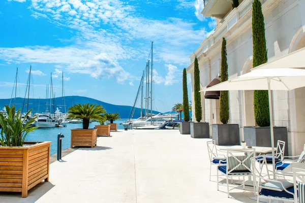 Tivat, Karadağ - 28 Haziran 2021: Porto Karadağ 'daki yat marinasının deniz kenarındaki konutları ve güzel gezinti alanlarıyla gün batımı manzarası