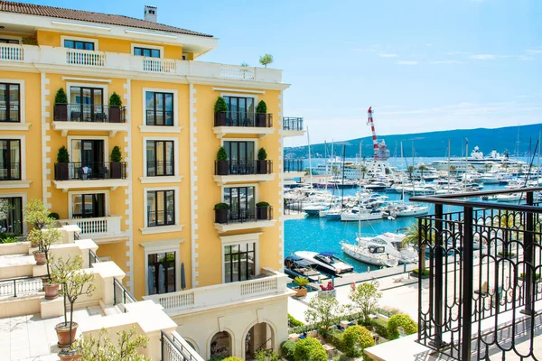 Tivat, Karadağ - 28 Haziran 2021: Porto Karadağ 'daki yat marinasının deniz kenarındaki konutları ve güzel gezinti alanlarıyla gün batımı manzarası