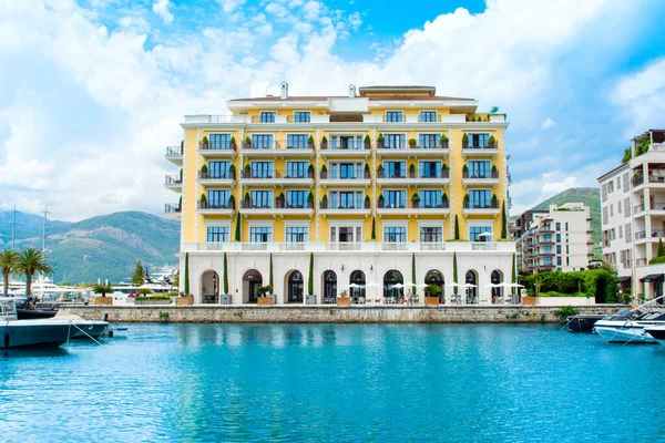 Tivat, Karadağ - 28 Haziran 2021: Porto Karadağ 'daki yat marinasının deniz kenarındaki konutları ve güzel gezinti alanlarıyla gün batımı manzarası