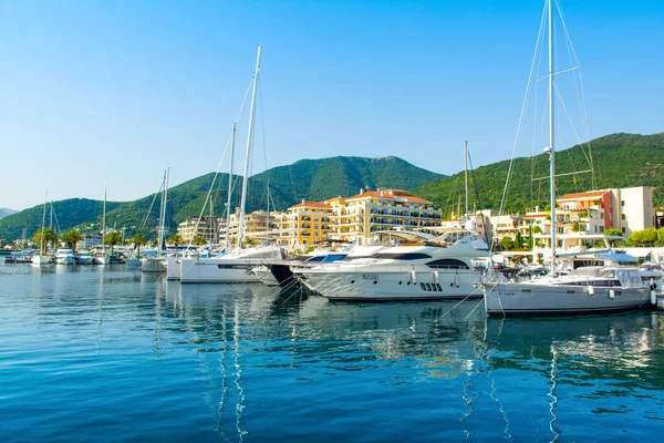 Tivat, Karadağ - 28 Haziran 2021: Porto Karadağ 'daki yat marinasının deniz kenarındaki konutları ve güzel gezinti alanlarıyla gün batımı manzarası