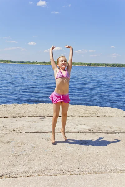 可爱的小女孩在粉红色泳装河岸 — 图库照片