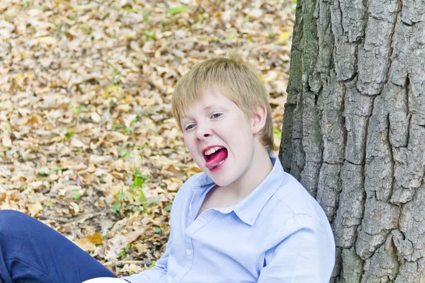Söt pojke med lägga ut tungan — Stockfoto