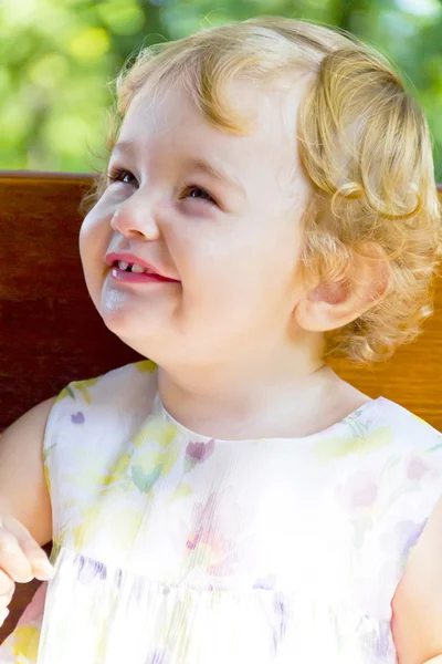 Criança sorridente com cabelo louro encaracolado — Fotografia de Stock