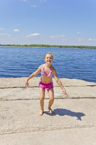 可爱的小女孩在粉红色泳装河岸 — 图库照片