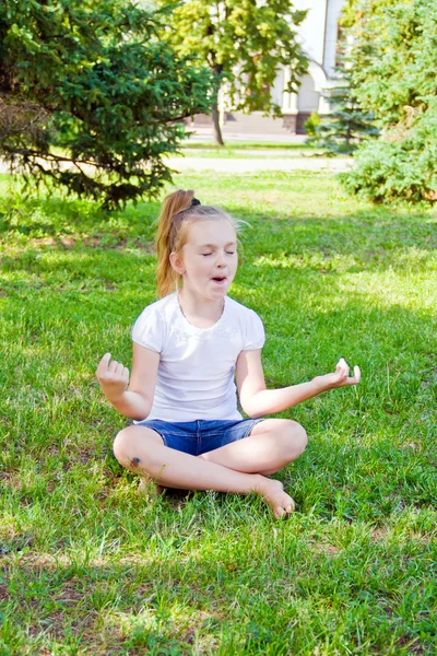 Söt tjej i lotus pose — Stockfoto