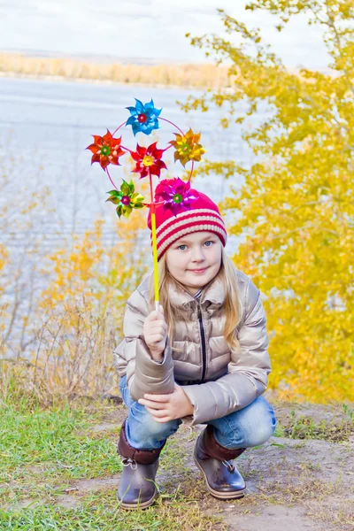Menina bonito no outono com brinquedo — Fotografia de Stock