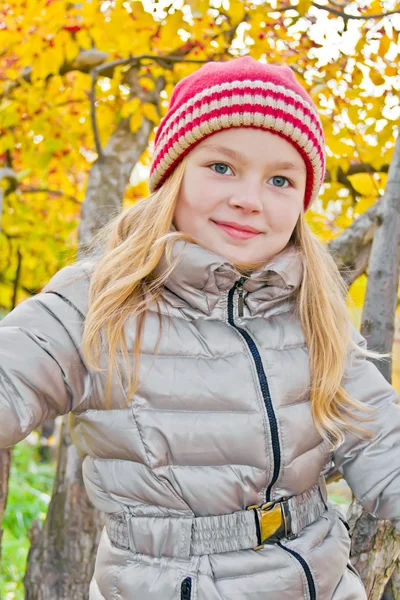 Menina bonito no outono sentar na árvore — Fotografia de Stock