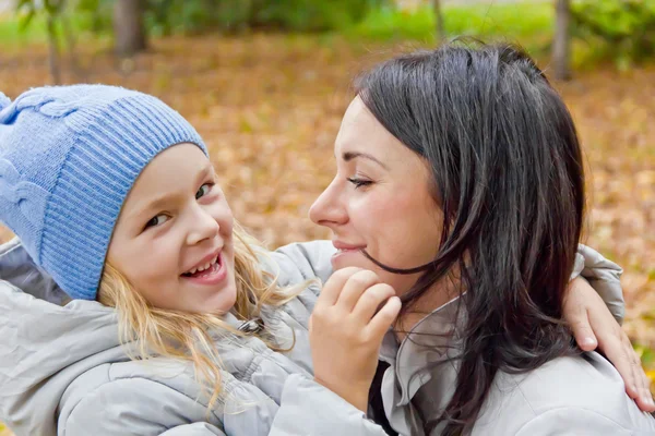 Smiling mother and daughter in autumn — Stock Photo, Image