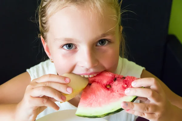 Sevimli kız karpuz ve kavun yemek — Stok fotoğraf