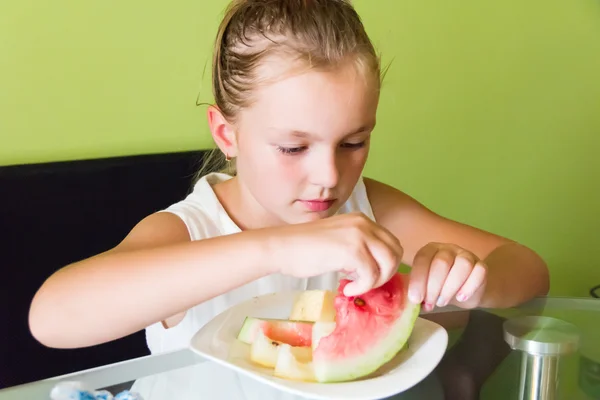 Söt flicka äter vattenmelon och melon — Stockfoto