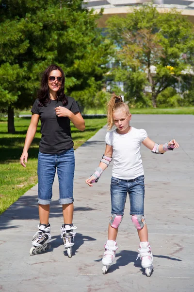 Moeder en dochter op rolschaatsen leren — Stockfoto