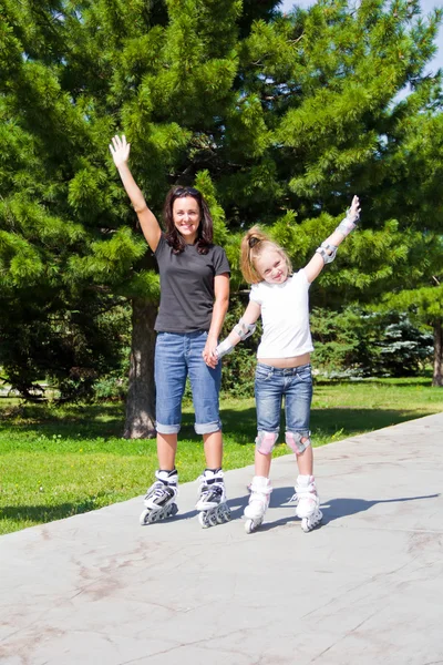 Mother and daughter on roller skates in summer — Stock Photo, Image