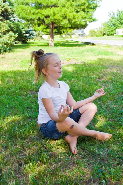 Söt tjej i lotus pose med ont knä — Stockfoto